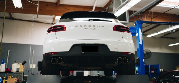 White Porsche sits on lift awaiting repair at Bavarium Autoworks, Mountain View, CA.